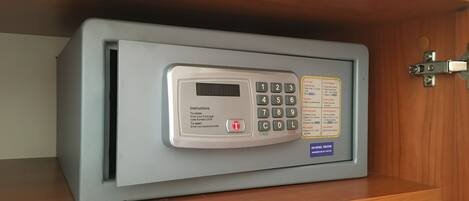 Un coffre-fort doté d’un clavier et accompagné d’instructions pour le verrouiller et le déverrouiller.