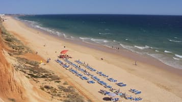 Playa en los alrededores, playa de arena blanca y sombrillas