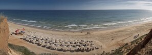 Plage à proximité, sable blanc, parasols, serviettes de plage
