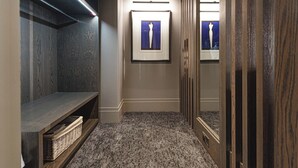 A hallway with a bench, a mirror, and framed artwork on the wall. - Dakota Eurocentral (Motherwell)