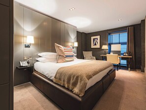 A modern hotel room with a large bed, bedside lamps, a desk, and a chair. - Dakota Eurocentral (Motherwell)