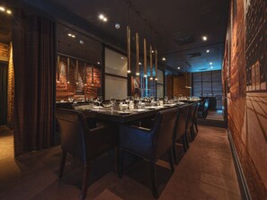 A restaurant with a long dining table, multiple chairs, and a modern interior design. - Dakota Eurocentral (Motherwell)