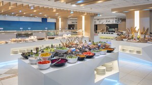 Un buffet proposant divers plats et une enseigne indiquant « Bon appétit Grill ».