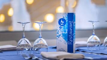 A table set with wine glasses and a menu box labeled "Restaurant Maritim."