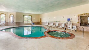 An indoor swimming pool with a hot tub, surrounded by lounge chairs and a staircase leading to an upper level. - Sleep Inn & Suites Hewitt - South Waco (Hewitt)