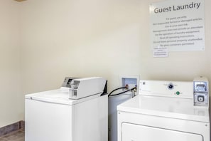 A guest laundry area with two washing machines and a sign detailing usage instructions. - Sleep Inn & Suites Hewitt - South Waco (Hewitt)