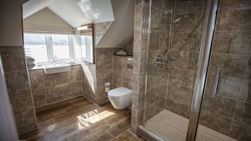A modern bathroom with a shower, toilet, and sink.