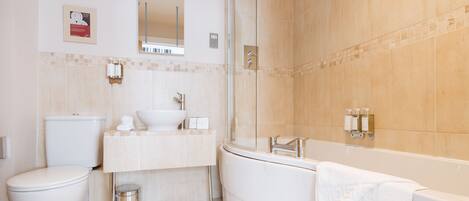 A modern bathroom with a toilet, sink, and bathtub.