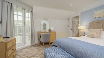 Une chambre d’hôtel avec un lit, un bureau, une chaise et une commode.