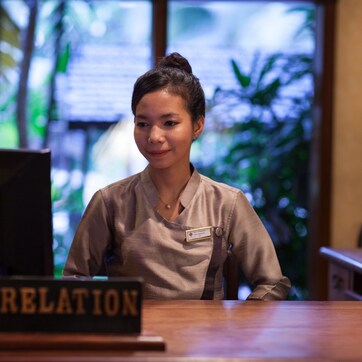 A reception desk with a sign reading "GUEST RELATION".