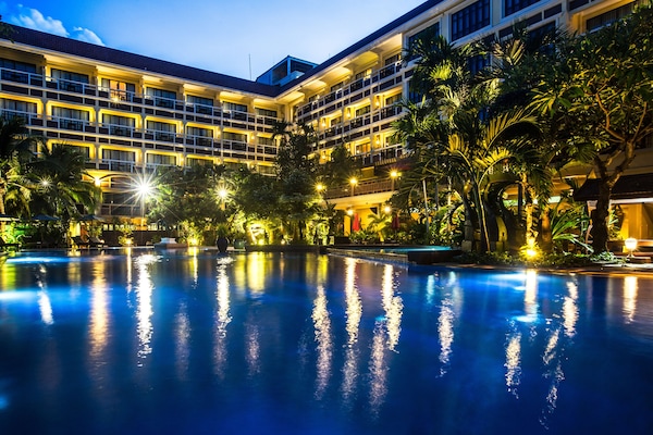 Una piscina al aire libre, sombrillas