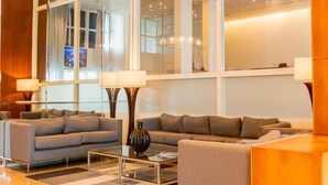 Un salon moderne avec deux canapés, une table basse en verre et des lampadaires.
