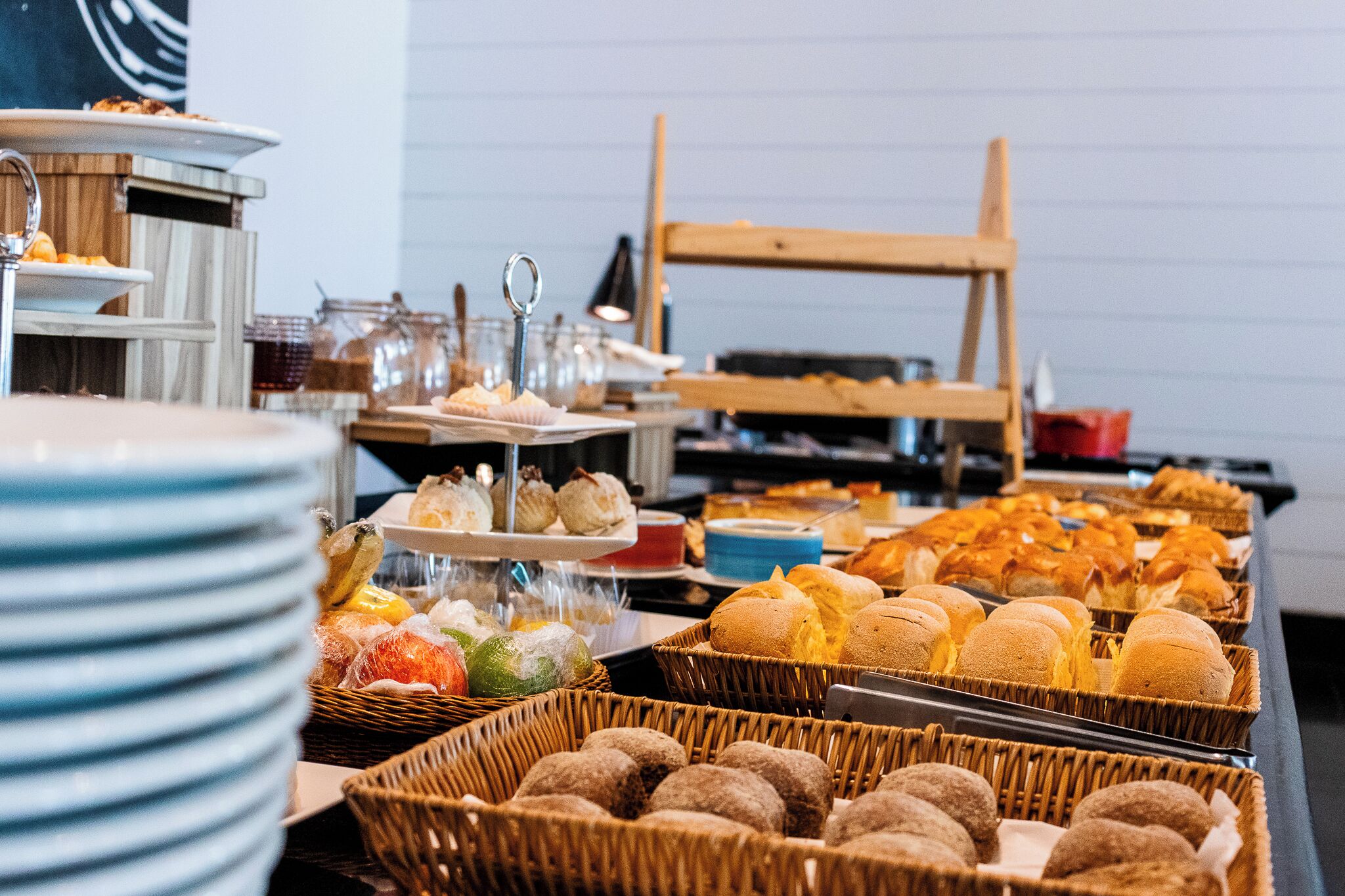 Un bufé con una variedad de alimentos, entre ellos bollería, frutas y bebidas.