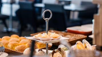 Una mesa de buffet con diversas opciones de pastelería y postres.