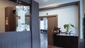 Een receptie met een houten balie, een potplant en een prikbord.
