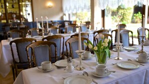 A dining area with tables set for service, featuring white tablecloths, silverware, and candles. - Hotel Garni Geisler (Cologne)
