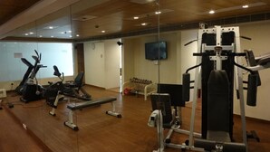 A gym with exercise equipment, a television, and a mirror. - Minerva Grand Secunderabad (Hyderabad)
