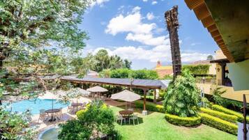 Un jardin avec une piscine, un espace salon extérieur et un aménagement paysager bien entretenu.