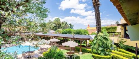 A backyard with a swimming pool, outdoor seating, and well-maintained landscaping.