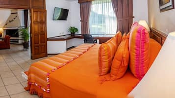 Una habitación de hotel con una cama, un escritorio, un televisor y vistas al exterior.