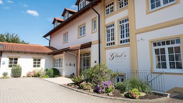 Experience the charm of Glast's Landhotel, a traditional hotel with a covered porch and beautifully landscaped gardens.