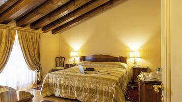 A bedroom with a wooden ceiling, a bed with a laptop, two bedside lamps, and a nightstand with a lamp.