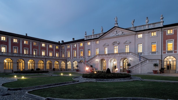 A large, historic building with multiple arched windows and a central staircase leading to a balcony. - Villa Fenaroli Palace Hotel (Rezzato)