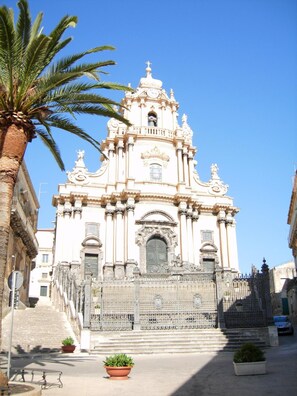 A historic church with ornate architecture, a bell tower, and a gated entrance. - Hotel Parco della Rocca (Ragusa)