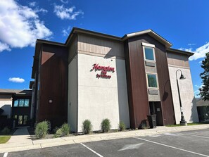 A building with a sign reading 'Hampton Inn by Hilton' and a parking lot in front. - Hampton Inn by Hilton Hailey Sun Valley (Hailey)