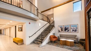 A spacious lobby with a staircase, a seating area with a sofa and chairs, and a patterned rug. - Hampton Inn by Hilton Hailey Sun Valley (Hailey)