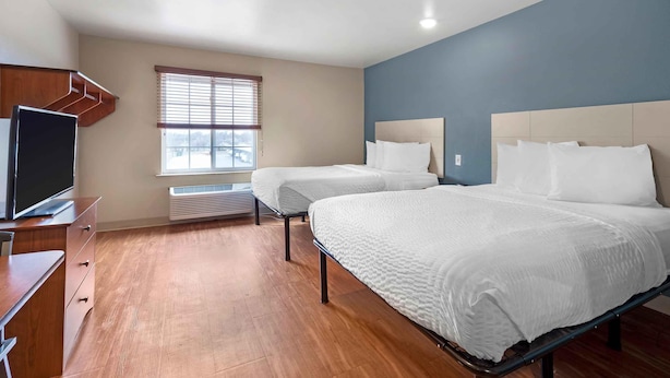A hotel room with two beds, a TV, a desk, and a window with blinds. - Extended Stay America Select Suites - Wichita - Airport (Wichita)
