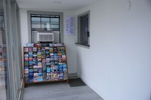 Un pasillo con un mostrador de revistas y un cartel de bienvenida.