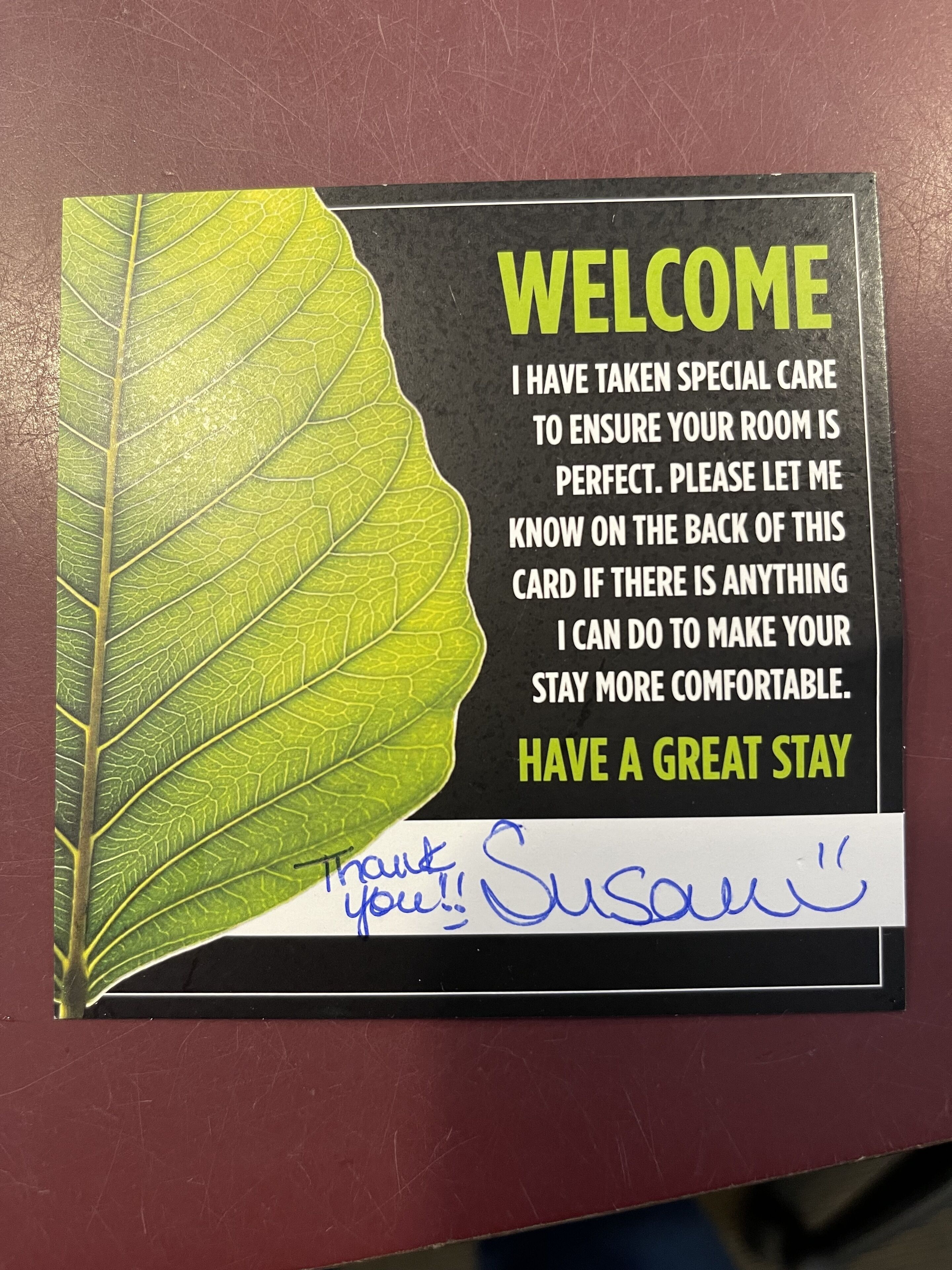 A welcome sign with a leaf design and a message about room care.