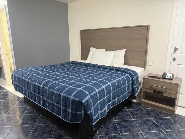 A hotel room with a bed, a nightstand, and a telephone.