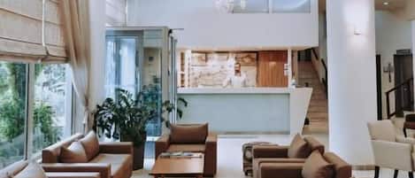 A spacious living area with sofas, a coffee table, and a view of the kitchen.
