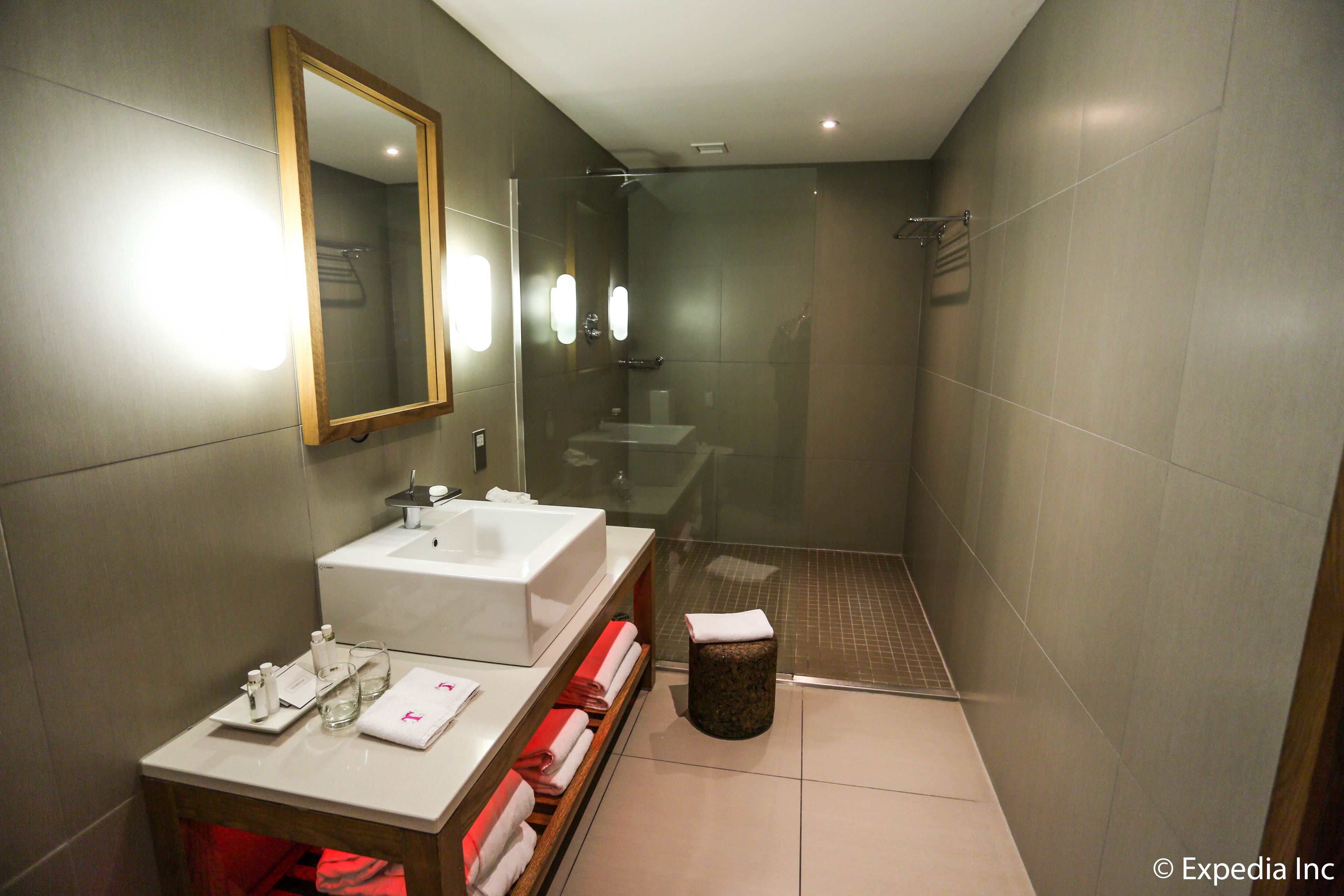 A modern bathroom with a glass-enclosed shower, a vanity with a sink, and a mirror.