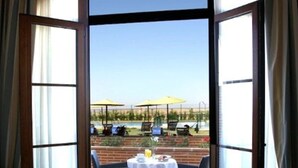 A room with a large glass door leading to an outdoor dining area with a table and chairs.