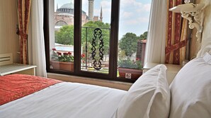 A hotel room with a large window offering a view of a mosque and cityscape. - The And Hotel Istanbul - Special Class (Istanbul)