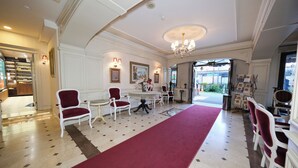 A spacious lobby with a red carpet, white chairs, a round table, and a chandelier. - The And Hotel Istanbul - Special Class (Istanbul)