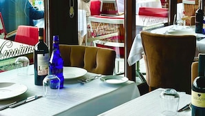 A restaurant with outdoor seating, tables set with plates, cutlery, and bottles of wine. - The And Hotel Istanbul - Special Class (Istanbul)