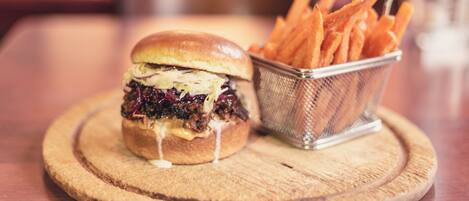 Una hamburguesa con papas fritas sobre una tabla de madera.