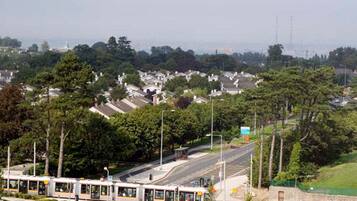 A bus station with a tram line, surrounded by residential buildings and greenery.