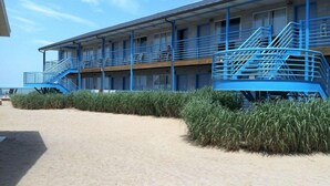 A beachfront motel with multiple balconies and a staircase. - Beachfront Resort (Port Clinton)