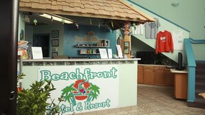 A beach-themed front desk area with a sign reading "Beachfront Resort." - Beachfront Resort (Port Clinton)