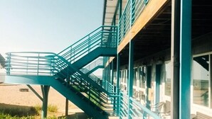 A building with a staircase leading to a covered area with seating. - Beachfront Resort (Port Clinton)