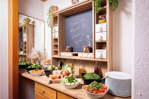 A kitchen counter with various food items, a chalkboard with text, and labeled jars. - AktiVital Hotel (Bad Griesbach im Rottal)