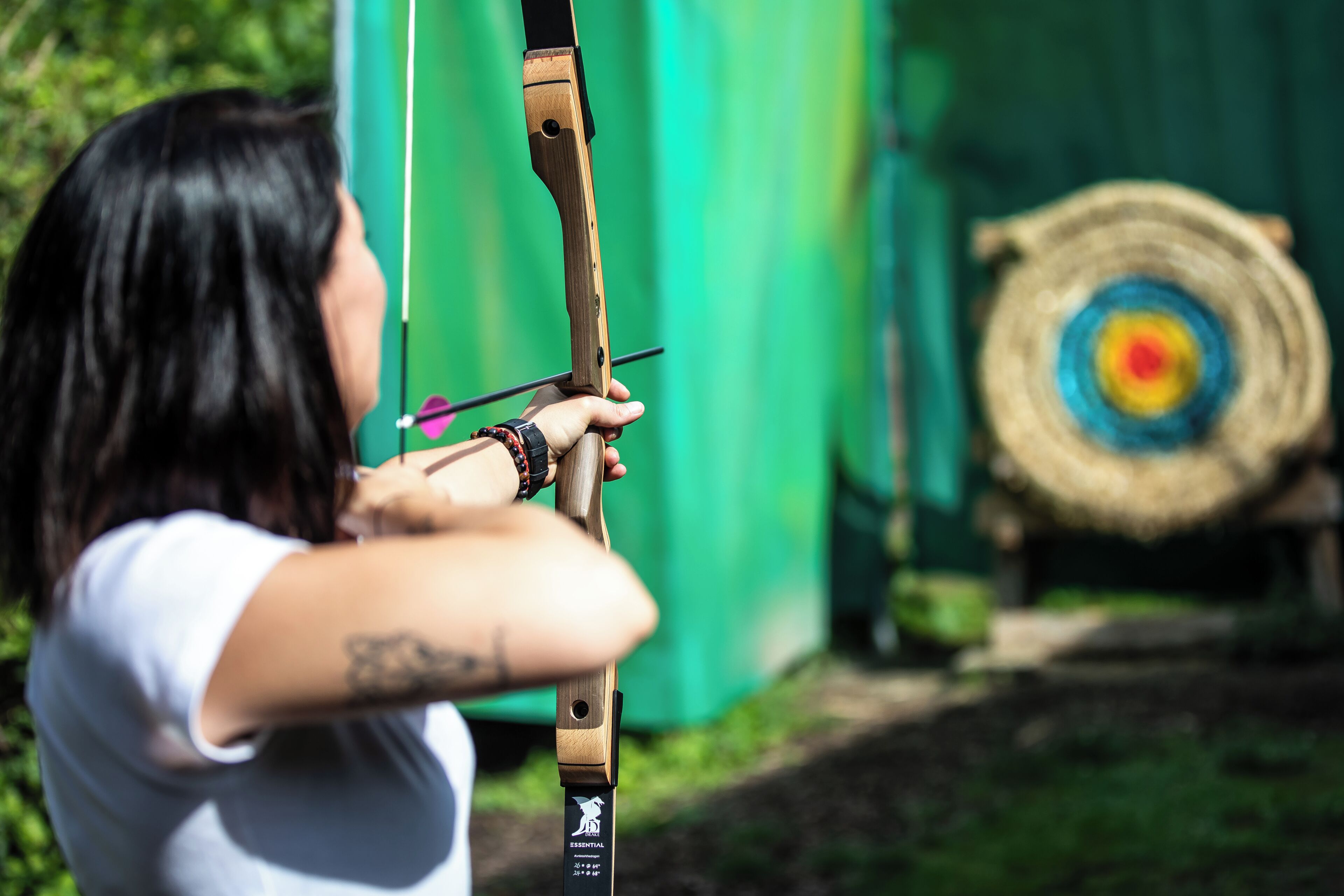 A person aiming a bow at a target.