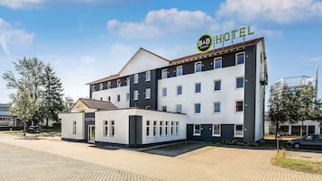 Een bed and breakfast hotel met een receptie, meerdere kamers en een parkeerplaats.