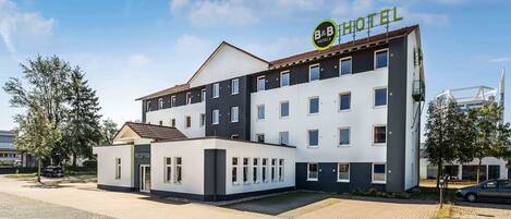 Un hotel B&B con recepción, varias habitaciones y aparcamiento.