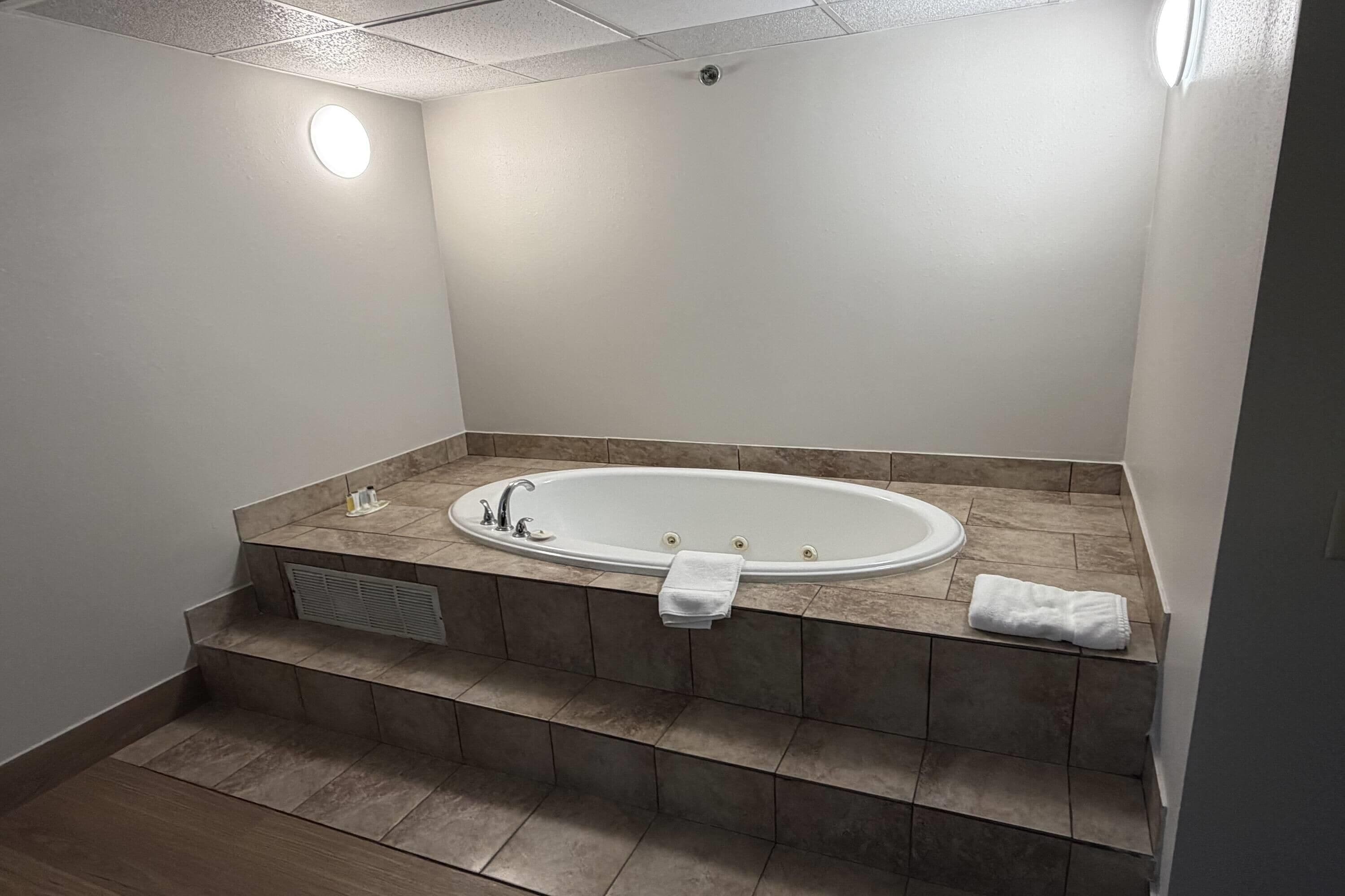 A modern bathroom with a freestanding bathtub, a towel rack, and a vent.